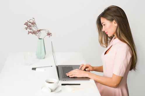 A focused woman managing proposals  diligently reviews them on her laptop, ensuring not to overlook the critical  timeline aspect of project management